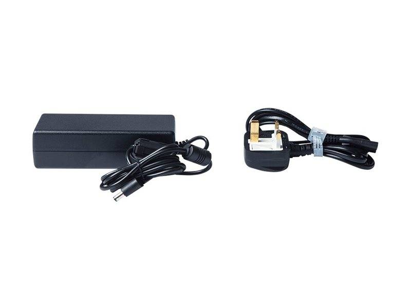 Schwarzer Stromadapter mit angebrachtem Kabel und aufgerolltem UK-Stecker-Kabel, gezeigt auf weißem Hintergrund.