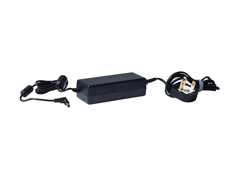 Schwarzer Netzteil mit angeschlossenem Kabel und britischem Stecker, auf weißem Hintergrund dargestellt.