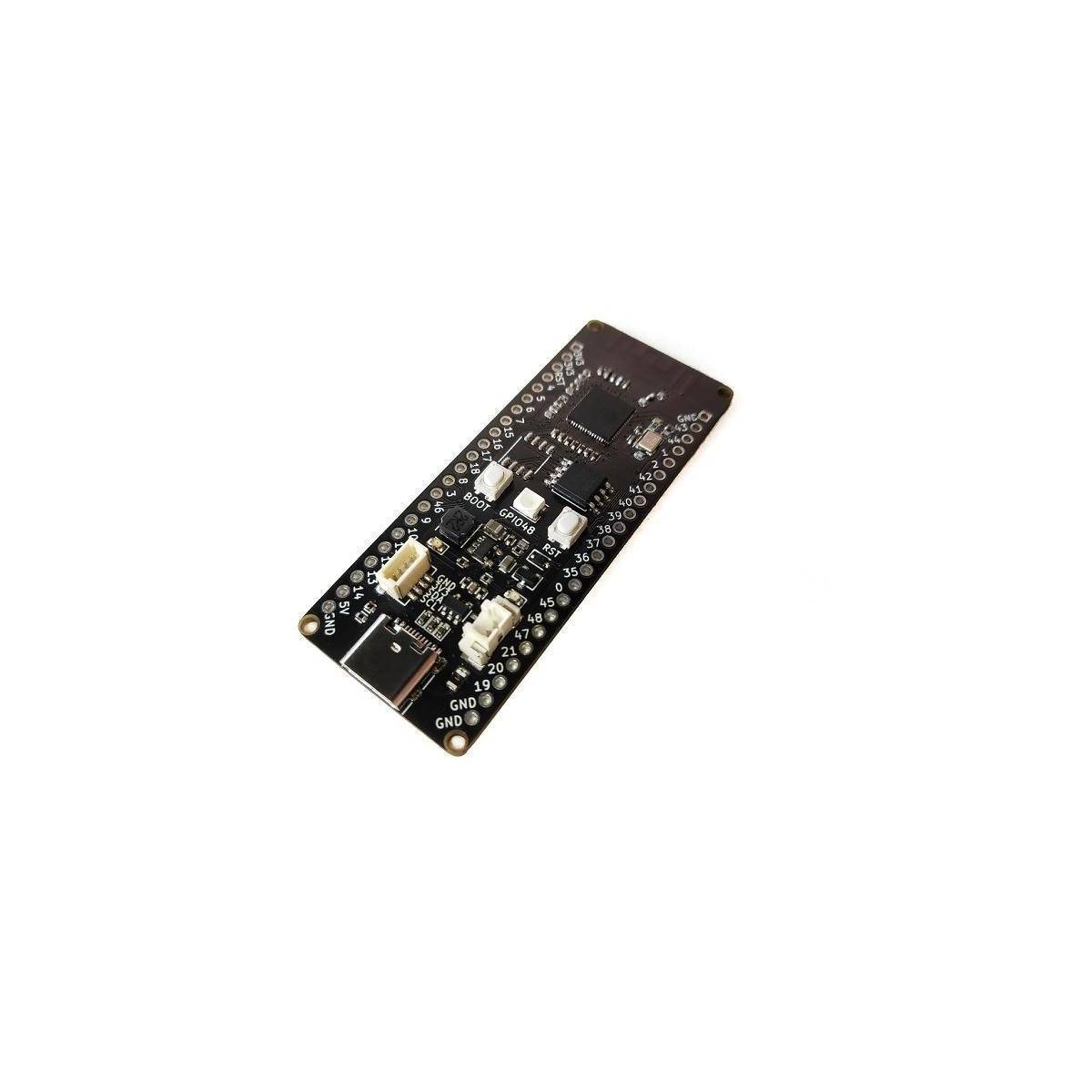 Ein schwarzer Mikrocontroller mit mehreren Pins, einem USB-Anschluss und beschrifteten Komponenten, der unter einem Winkel auf weißem Hintergrund präsentiert wird.