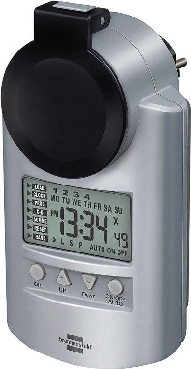 Digitale Uhr mit großem Display, das 13:34 anzeigt. Tasten für Uhr, Programm und Zufallseinstellungen. Wochentage oben beschriftet.