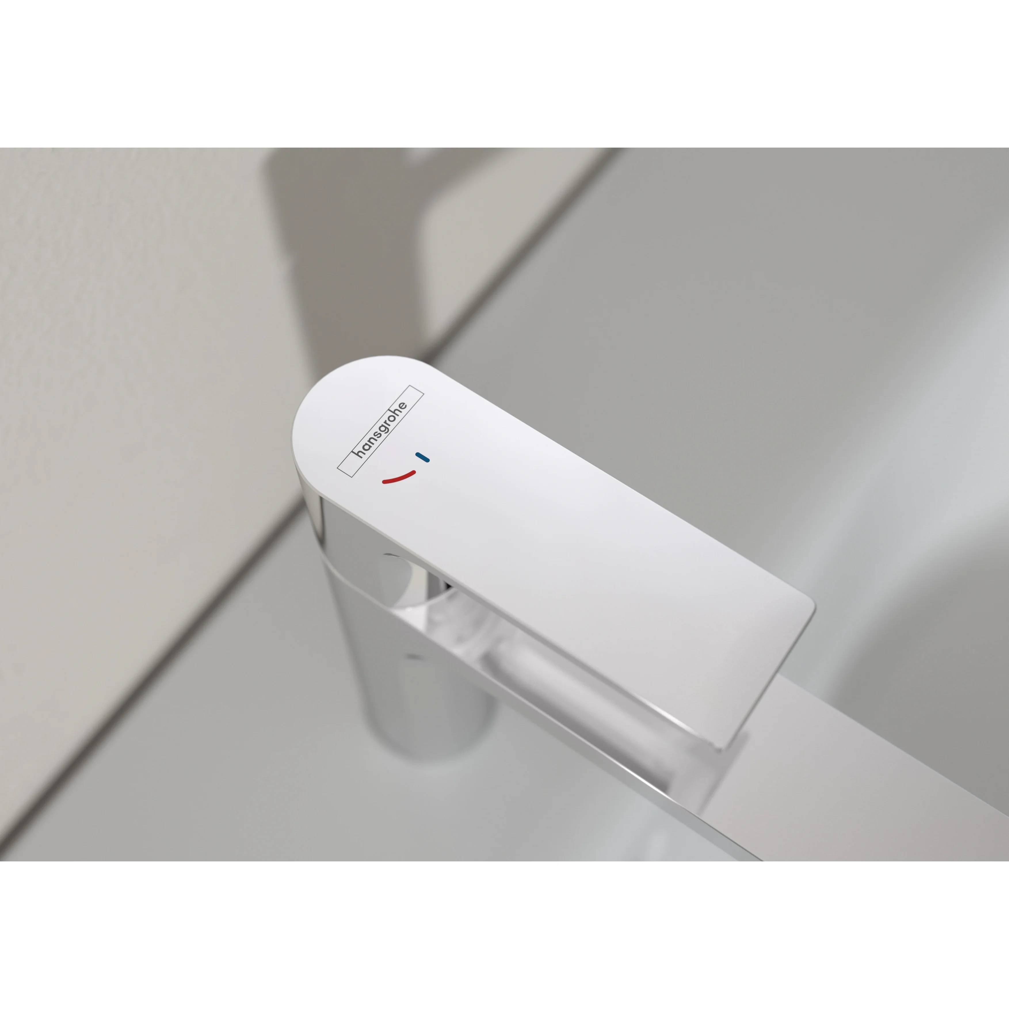 Nahaufnahme eines weißen Hansgrohe-Armaturengriffs mit roten und blauen Temperaturmarkierungen an einer Waschbecken- oder Badewannenarmatur.