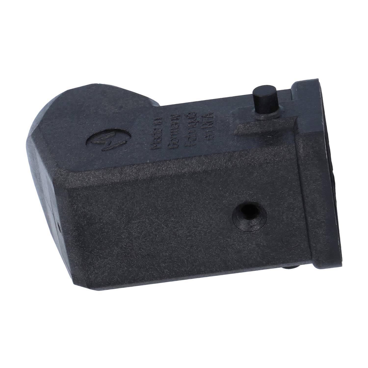 Eine Nahaufnahme eines schwarzen Kunststoffsteckers oder Adapters mit zwei kleinen vorstehenden Stiften oben und einem Loch an der Seite, vor einem weißen Hintergrund platziert.