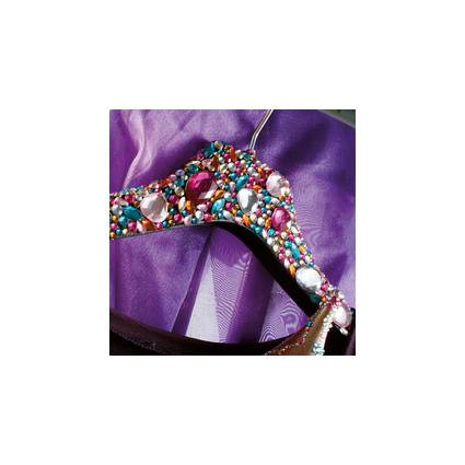 Ein lebhafter, mit Juwelen geschmückter Kleiderbügel mit mehrfarbigen Edelsteinen und Perlen vor einem lila Satin-Hintergrund.