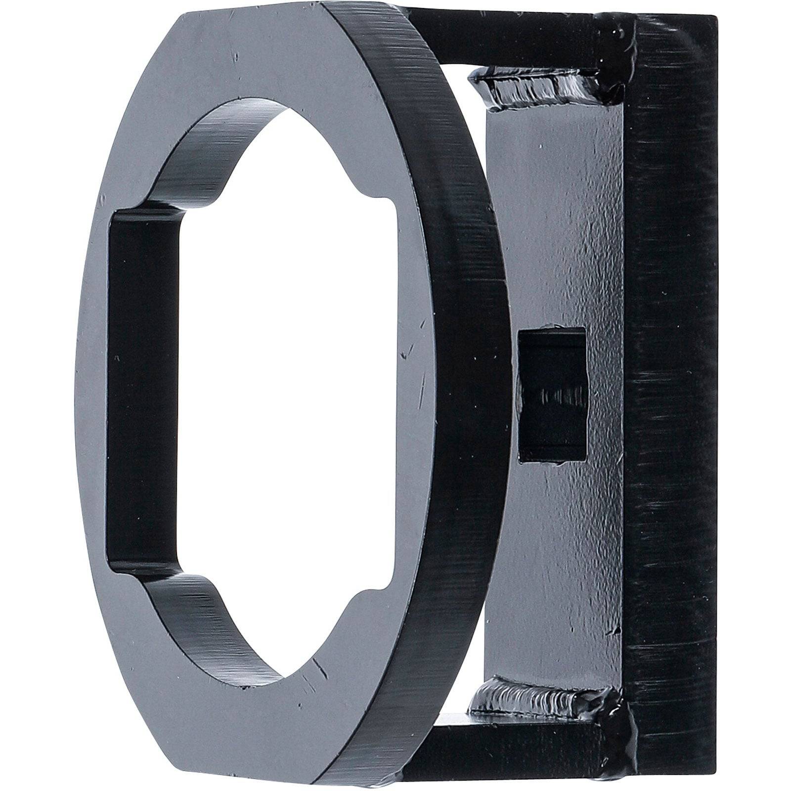 Ein schwarzes, rechteckiges Metallobjekt mit einer kreisförmigen Öffnung, das einem Halter oder einer Halterung ähnelt, aufrecht auf einem weißen Hintergrund platziert.