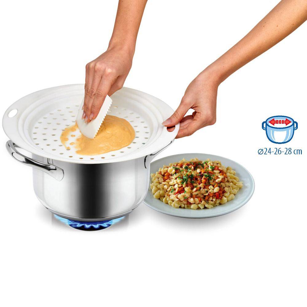Hand, die einen Deckel auf einen Topf mit dampfendem Gericht legt, während eine andere Hand einen Teller mit bunter Pasta daneben hält.