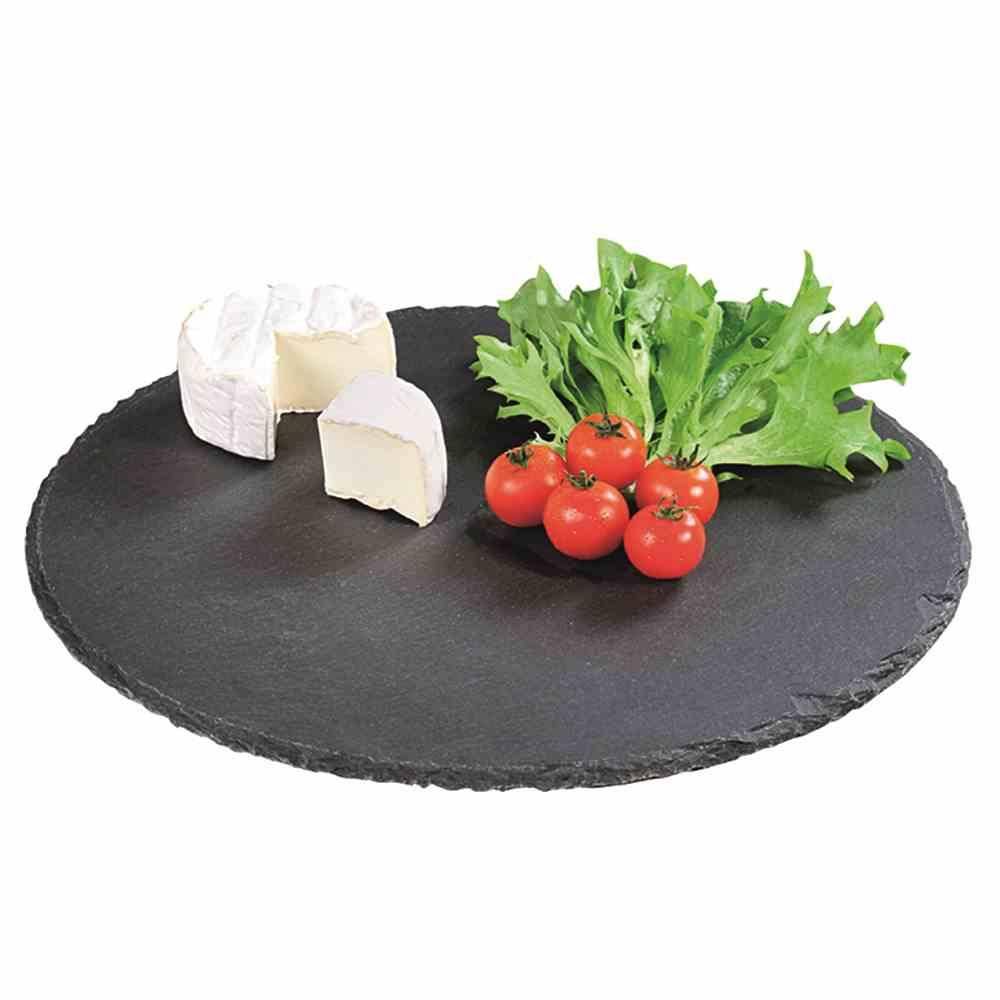 Ein rundes Schieferplatte, auf dem ein Stück Weichkäse, eine Traube roter Kirschtomaten und einige grüne Salatblätter ordentlich angeordnet sind.