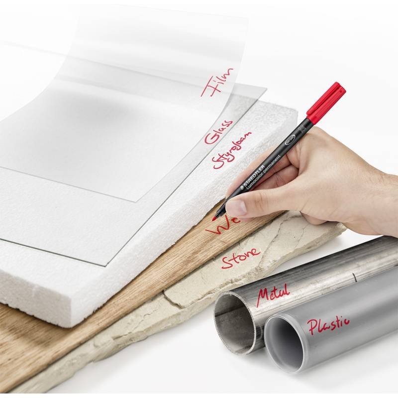 Eine Hand schreibt auf verschiedenen Oberflächen, darunter Papier, Film, Glas, Styropor, Holz, Stein, Metall und Kunststoff mit einem roten Stift.