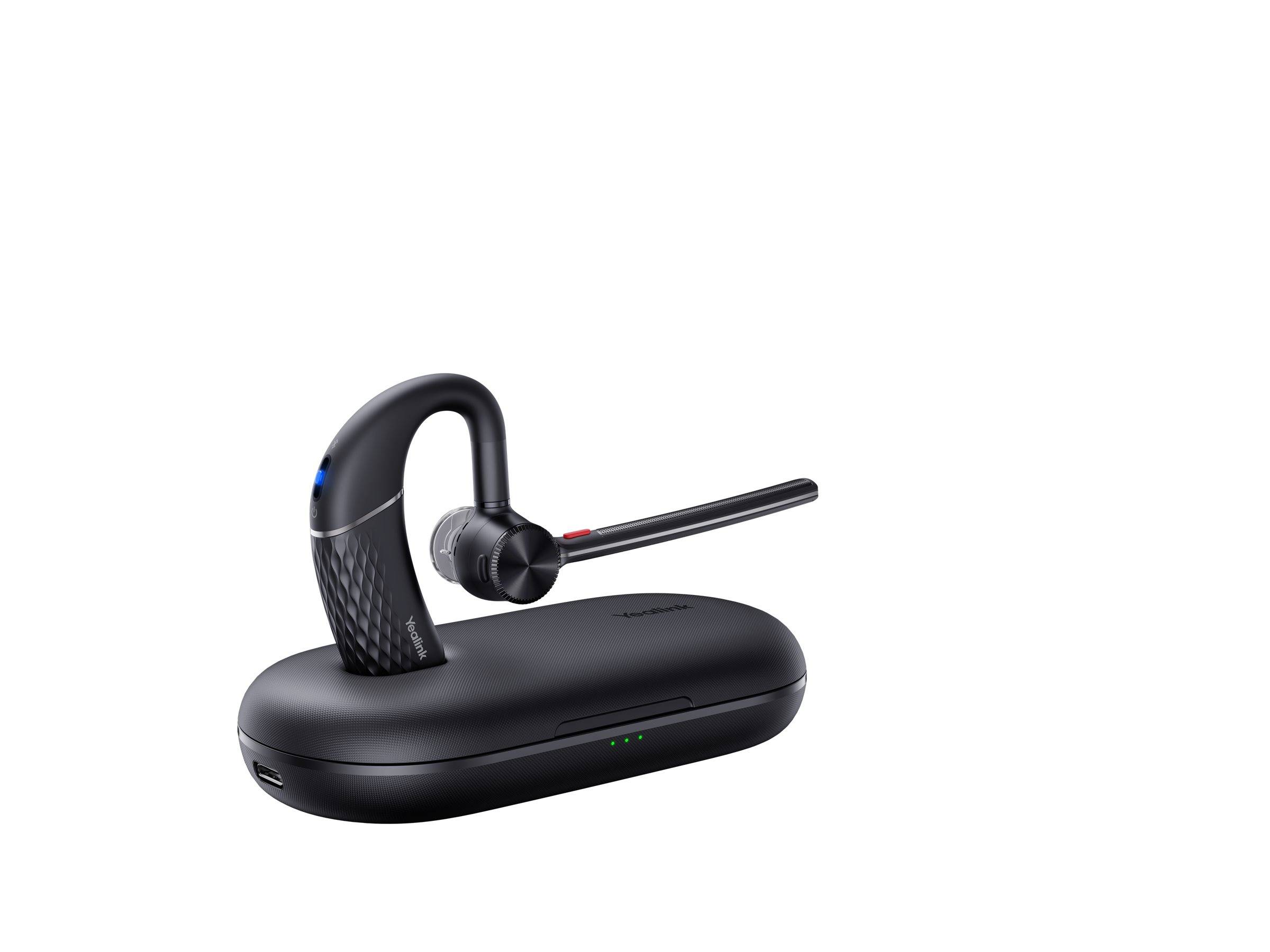 Schwarzes kabelloses Bluetooth-Headset auf einer Ladestation, in der Profilansicht vor weißem Hintergrund gezeigt.