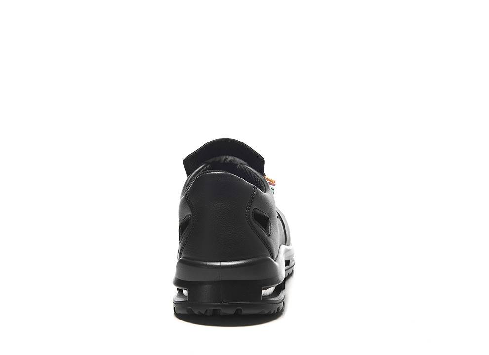 Eine Nahaufnahme der Rückansicht eines einzelnen schwarzen Sneakers, die dessen Profilmuster und Design zeigt, vor einem einfarbigen weißen Hintergrund.