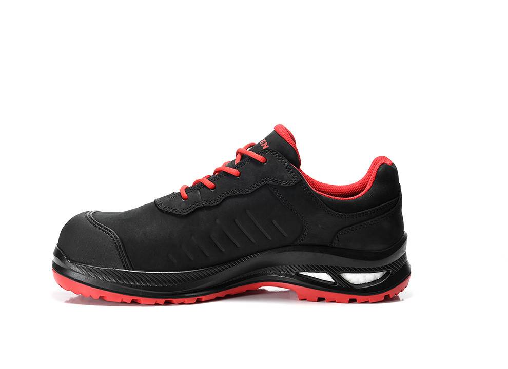 Ein schwarzer Sportschuh mit roten Akzenten und einer strukturierten Sohle, von der Seite gezeigt, der sein sportliches Design und seine Langlebigkeit betont.