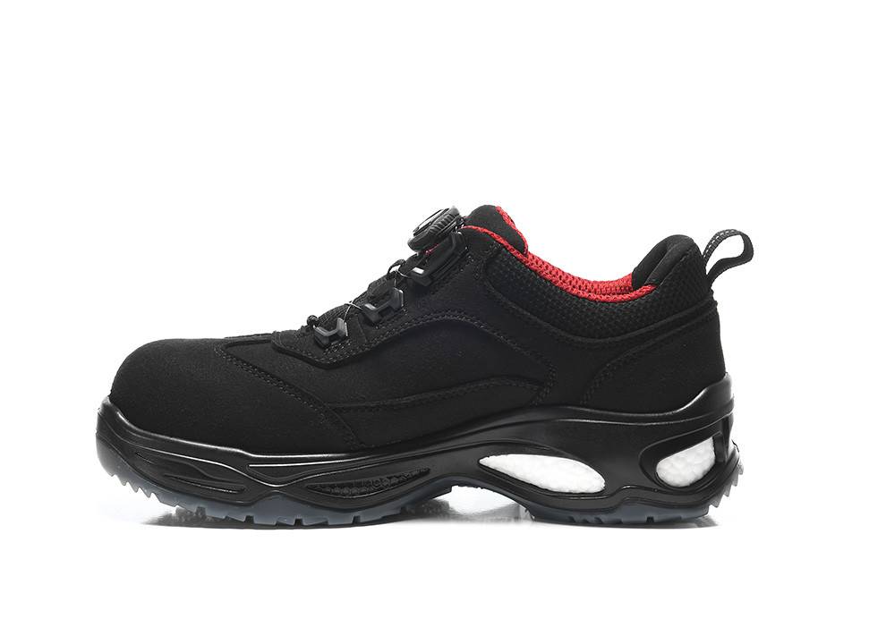 Ein schwarzer Sportschuh mit roter Innenfütterung und einer dicken, strukturierten Sohle wird in Seitenansicht gezeigt.