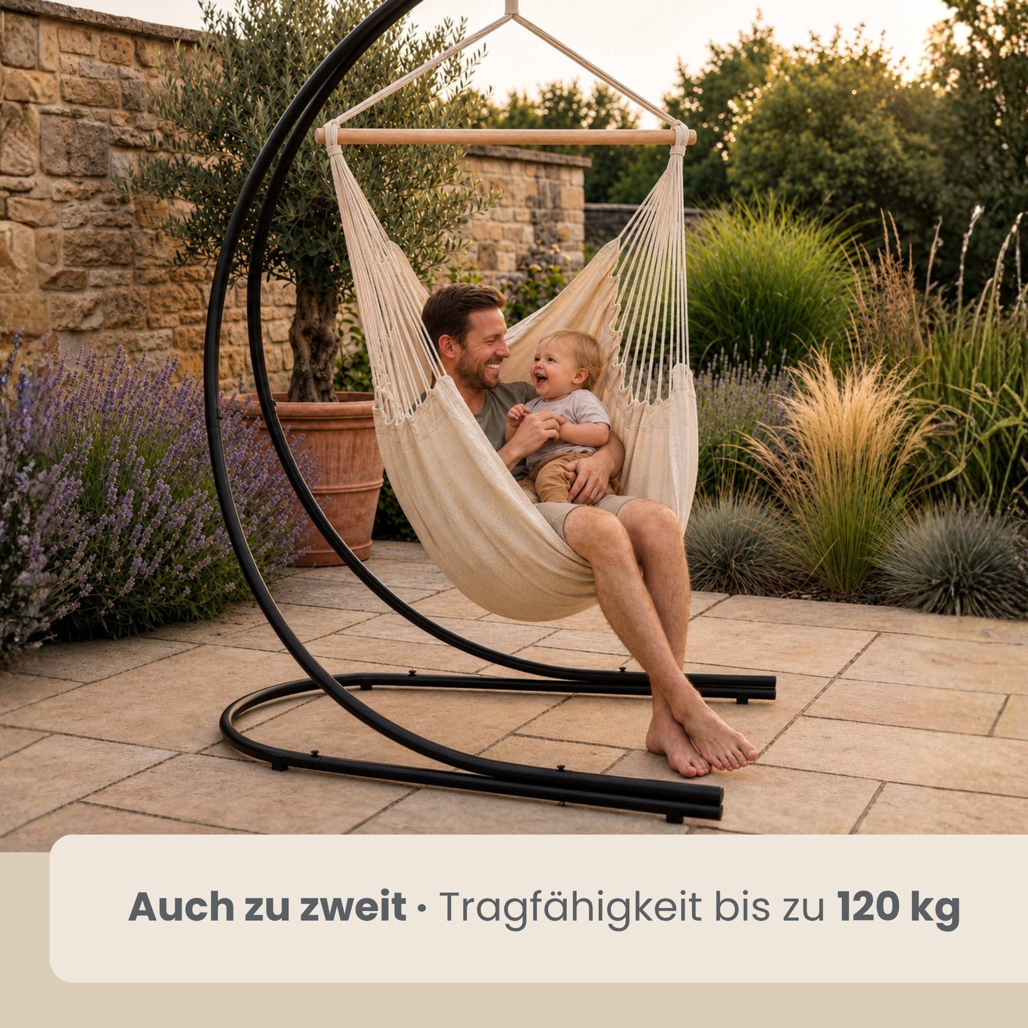 Mann und lächelndes Baby sitzen zusammen in einem hängenden Hängesessel im Freien; die Beschriftung besagt „Auch zu zweit · Tragfähigkeit bis zu 120 kg