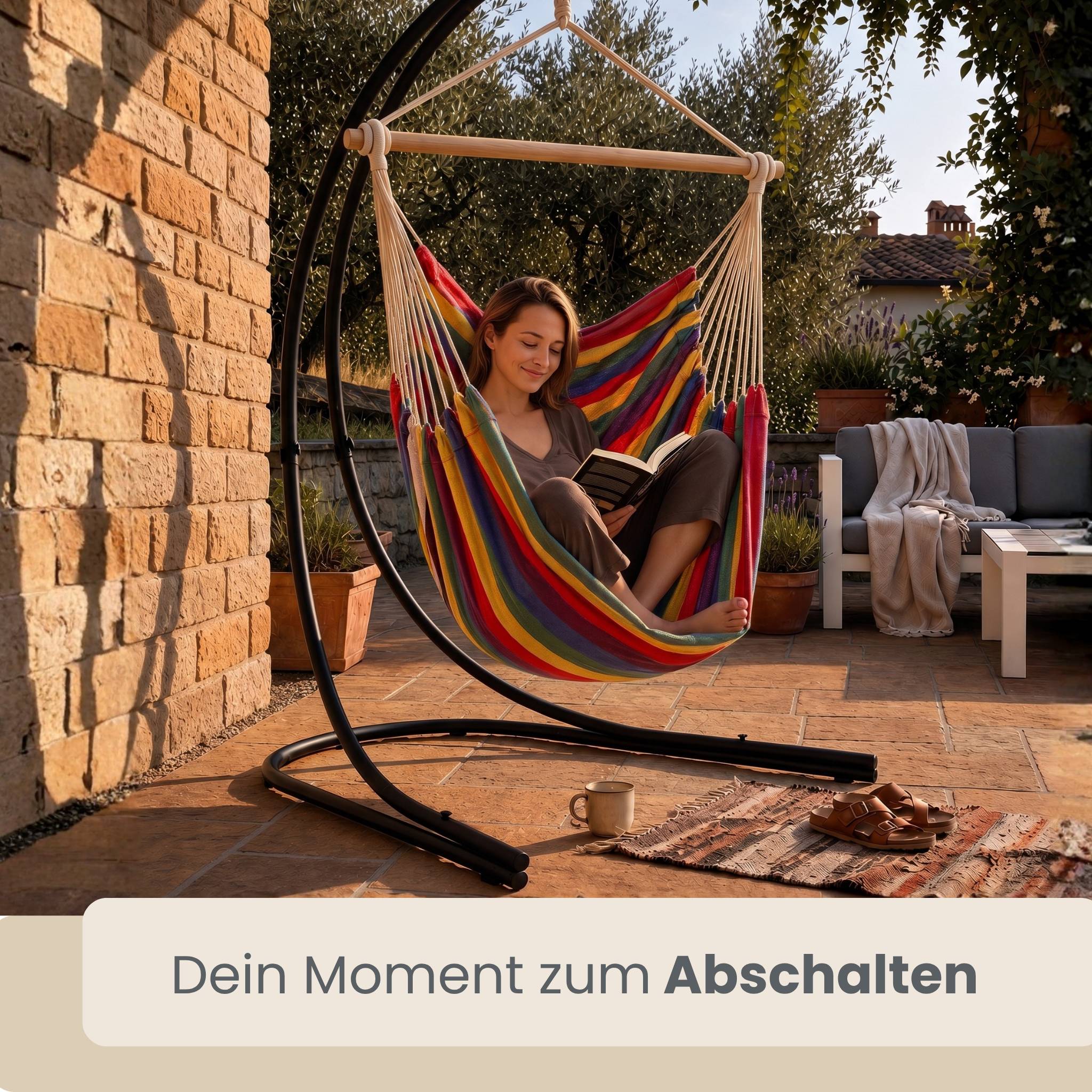 Frau, die in einem Regenbogen-Hängesessel auf einer sonnigen Terrasse liest, mit deutschem Text „Dein Moment zum Abschalten