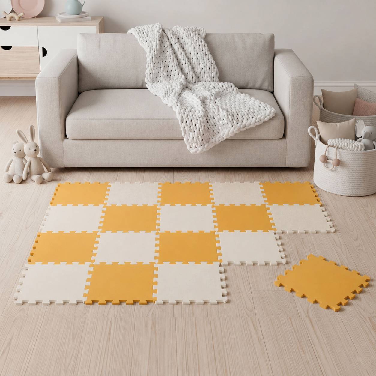 Gemütliches Wohnzimmer mit beigem Sofa und Decke, mit gelben und cremefarbenen Schaumstoff-Puzzlematten auf dem Holzboden arrangiert.