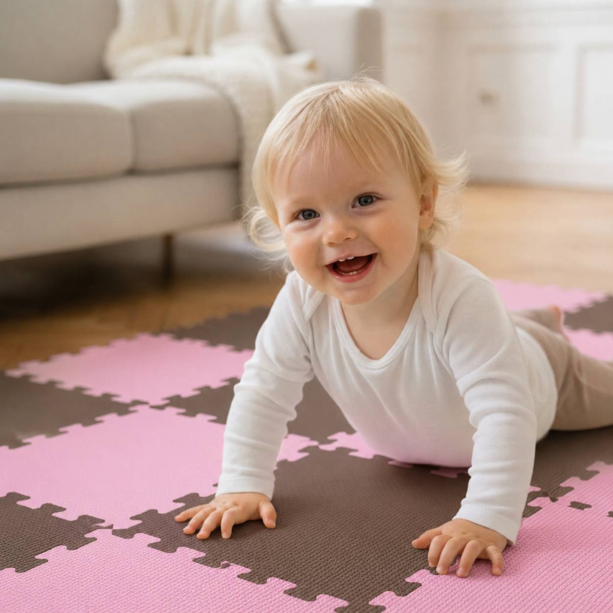 Lächelndes Kleinkind auf Händen und Knien auf einer rosa und braunen Spielmatte im Wohnzimmer.