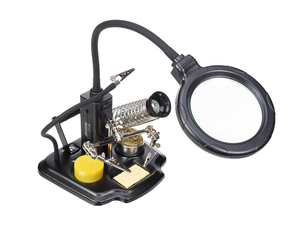 Eine Lötstation mit verstellbarer Lupe, Lötkolbenhalter und Lötschwamm, die für elektronische Arbeiten verwendet wird.