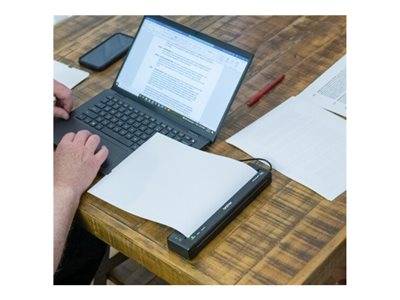 Eine Person scannt ein Dokument mit einem tragbaren Scanner, der neben einem Laptop auf einem Holztisch platziert ist, während sich ein Smartphone in der Nähe befindet.