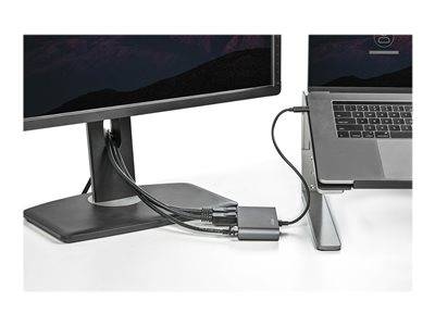 Laptop mit zwei Monitoren verbunden, unter Verwendung eines Multi-Port-Adapters, aufgestellt auf einem Ständer. Kabel sind sauber organisiert und deuten auf einen aufgeräumten Arbeitsplatz hin.