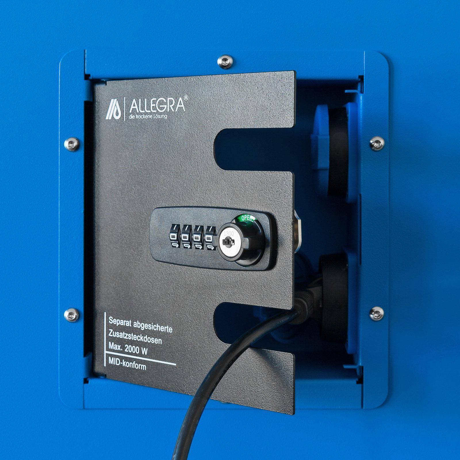 Ein verschlossenes ALLEGRA-Elektrozugriffsfeld in einer blauen Wand mit einem Kombinationsriegel und einem Stromkabel, das in eine geschützte Steckdose eingesteckt ist.