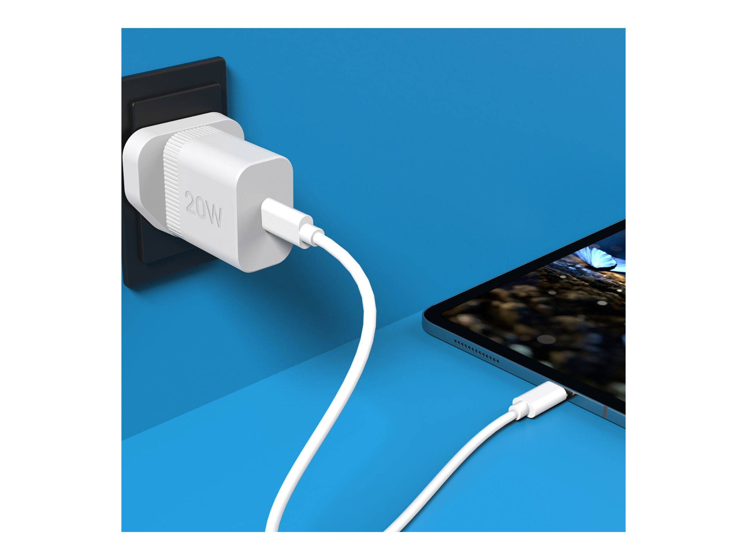 Ein weißes 20-W-Wandladegerät, das in eine schwarze Steckdose gesteckt ist, lädt ein Smartphone mit einem weißen Kabel auf einer blauen Oberfläche auf.
