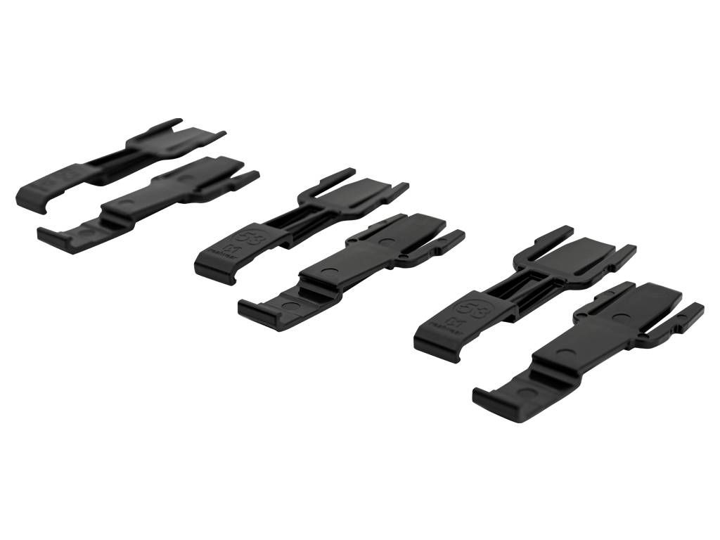 Vier schwarze Kunststoff-Schnappkabelclips auf weißem Hintergrund angeordnet.