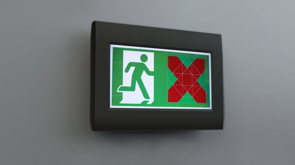 Notausgang-Schild mit einer Person, die auf der linken Seite durch eine Tür läuft; großes rotes Kreuz auf der rechten Seite, das Betreten verboten signalisiert.