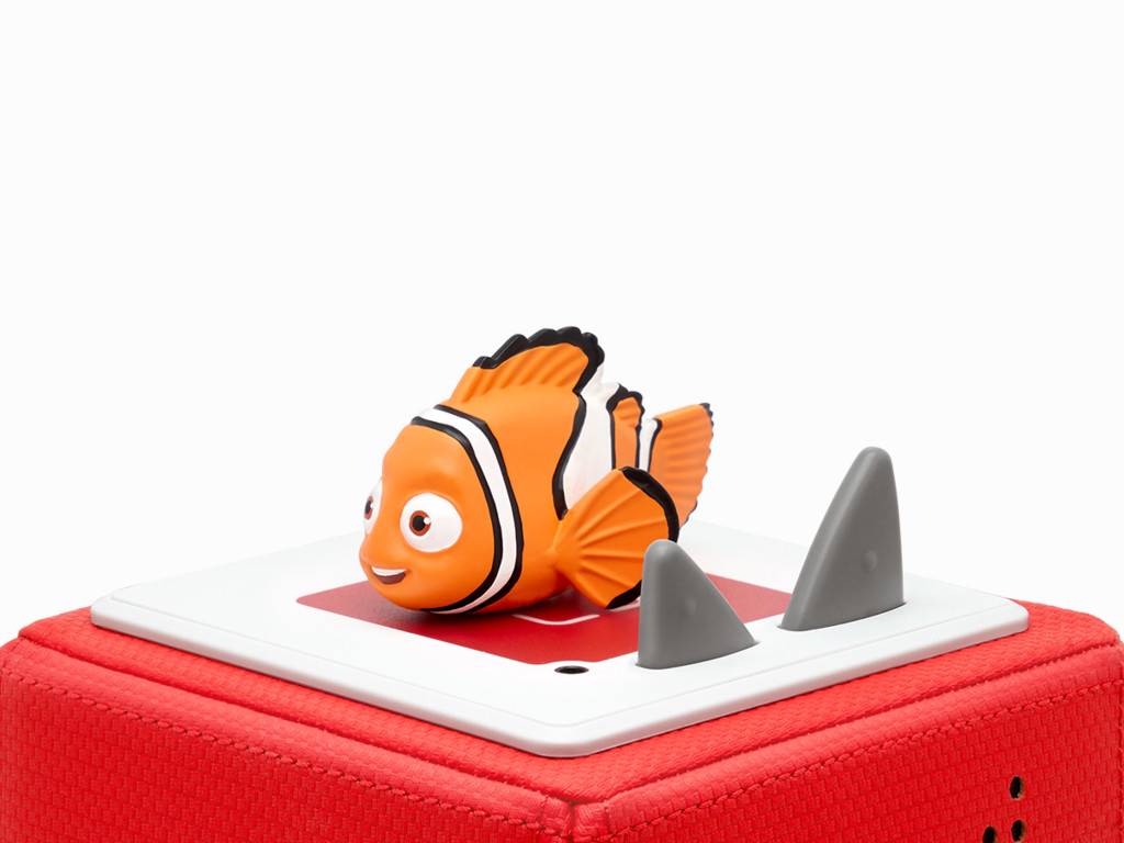 Orange-weiße Clownfischfigur auf einer weißen Oberfläche, mit zwei grauen kegelförmigen Hindernissen davor, montiert auf einer roten strukturierten Basis.