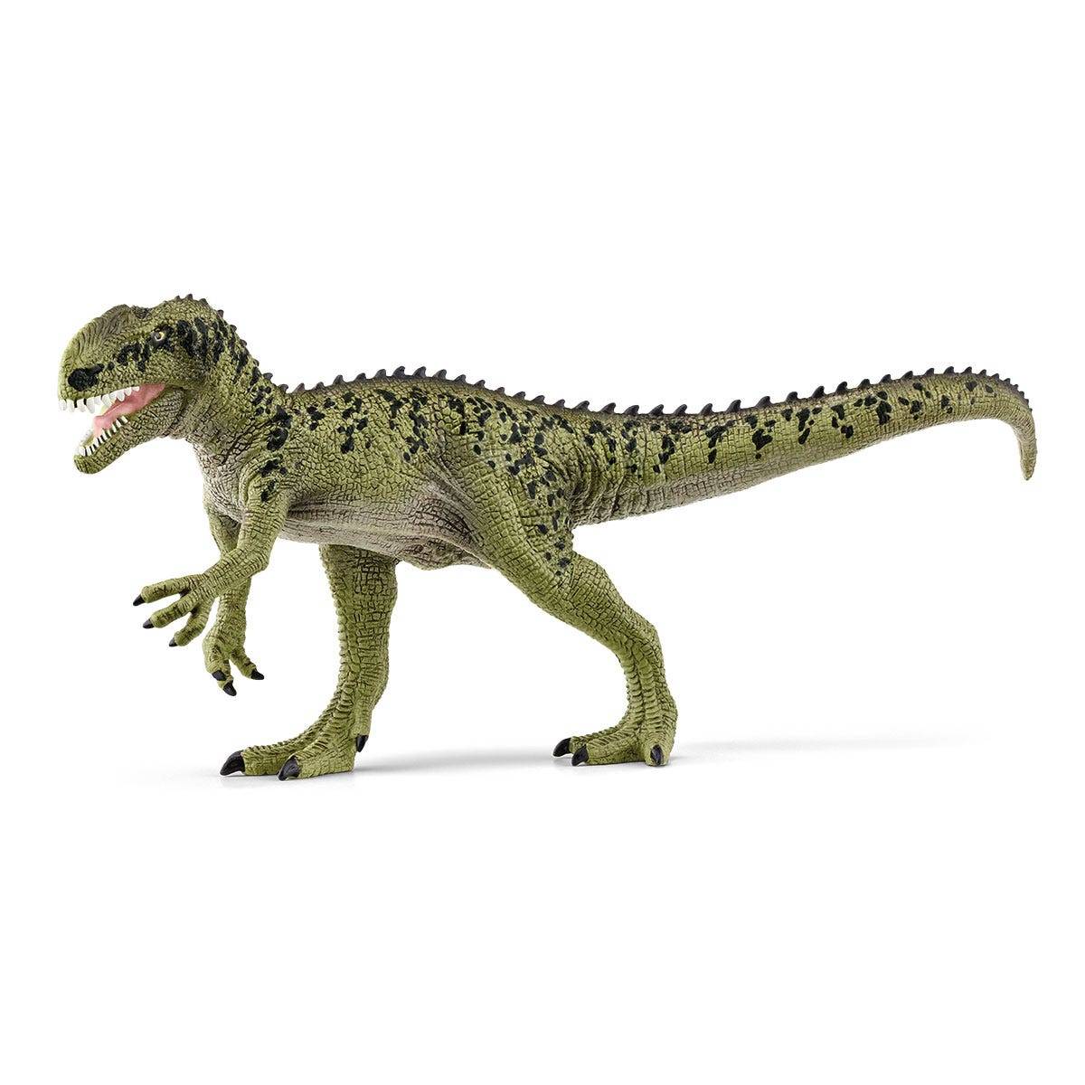 Grüne T.-rex-Spielzeugfigur in Seitenansicht, stehend auf weißem Hintergrund mit offenem Maul und ausgestrecktem Schwanz.