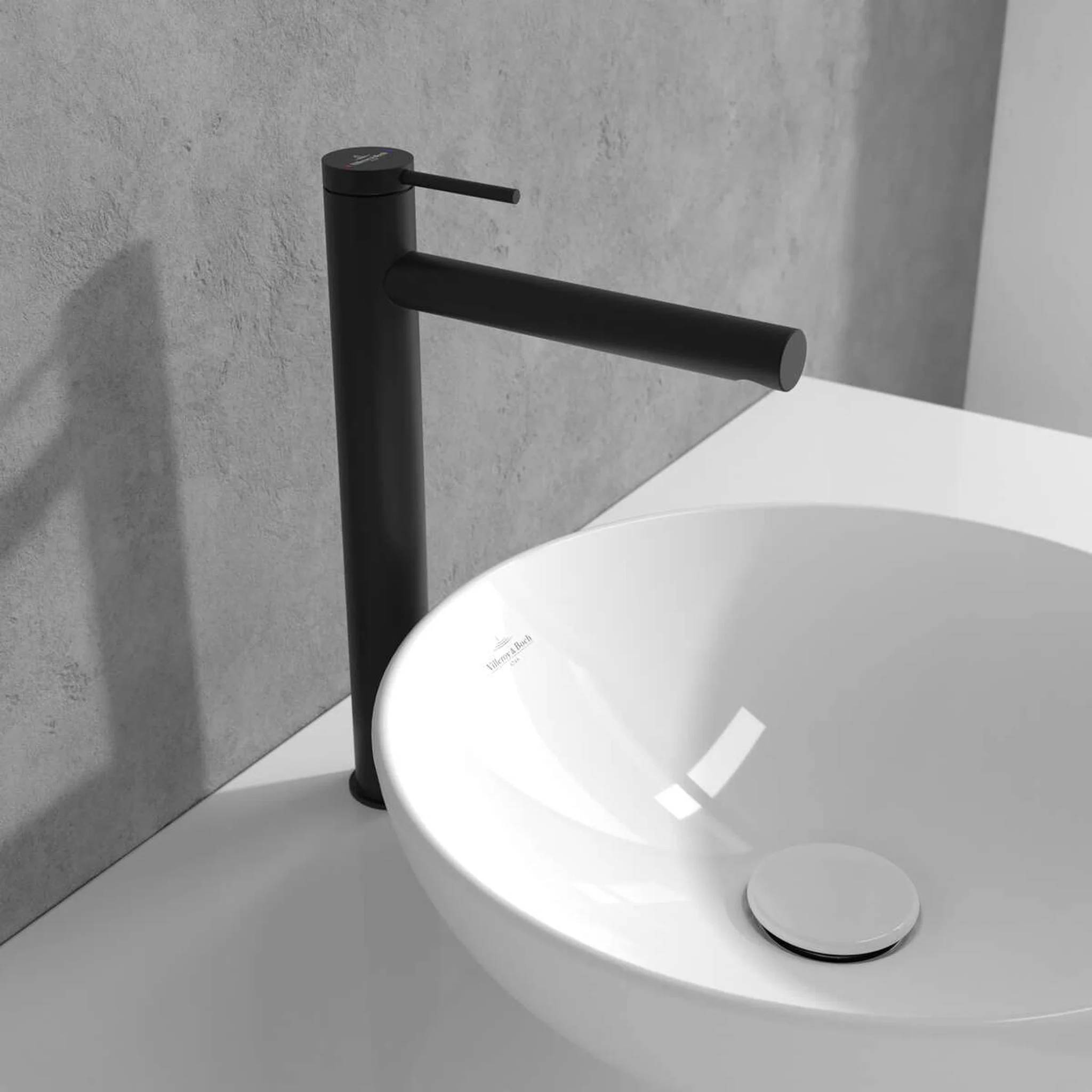 Moderner schwarzer Wasserhahn über einem weißen runden Aufsatzwaschbecken in einem minimalistischen Badezimmer.