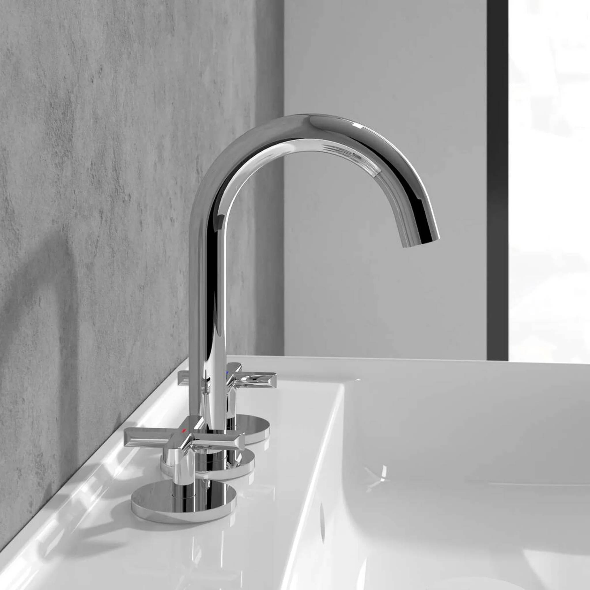 Chrom-Badezimmerhahn über einem weißen Waschbecken, vor einer graufliesigen Wand.