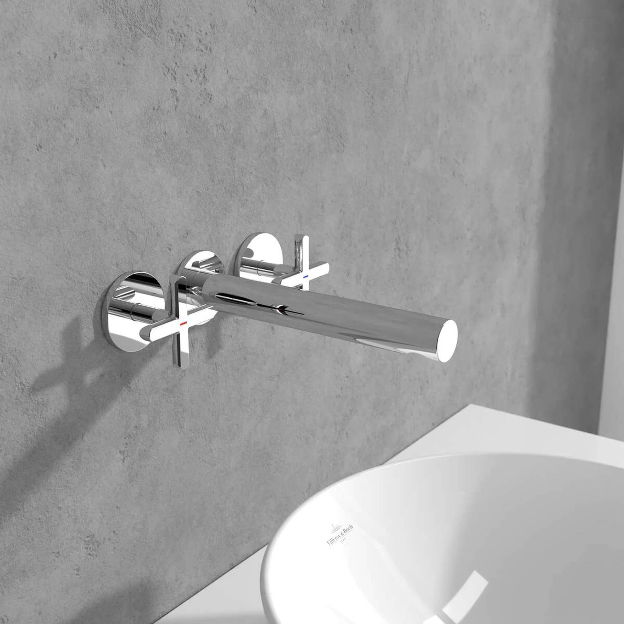 Wandmontierter Chrom-Badewannenhahn mit zwei Kreuzhebeln über einer weißen Wanne an einer grauen Betonwand.