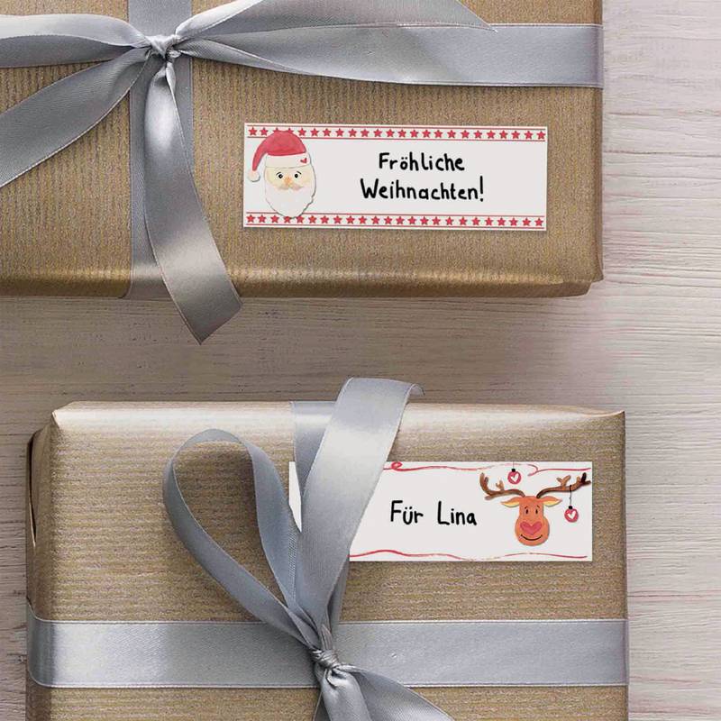 Zwei ordentlich verpackte Geschenke mit silbernen Bändern. Ein Anhänger zeigt 'Fröhliche Weihnachten!' mit einem Weihnachtsmann-Bild, der andere 'Für Lina' mit einem Rentier-Bild.