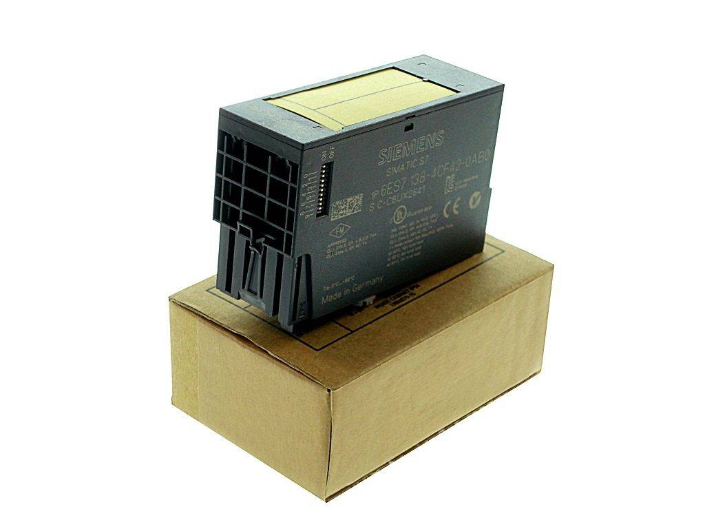 Schwarzes industrielles elektronisches Modul, das auf einem Kartonkarton vor weißem Hintergrund ruht.