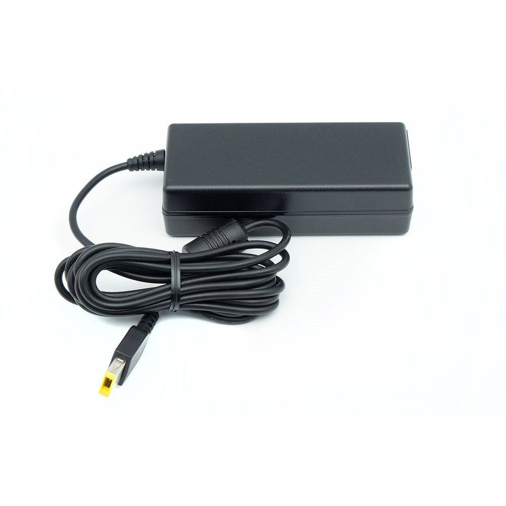 Schwarzer Stromadapter mit Spiralkabel und gelbem Stecker auf weißem Hintergrund.