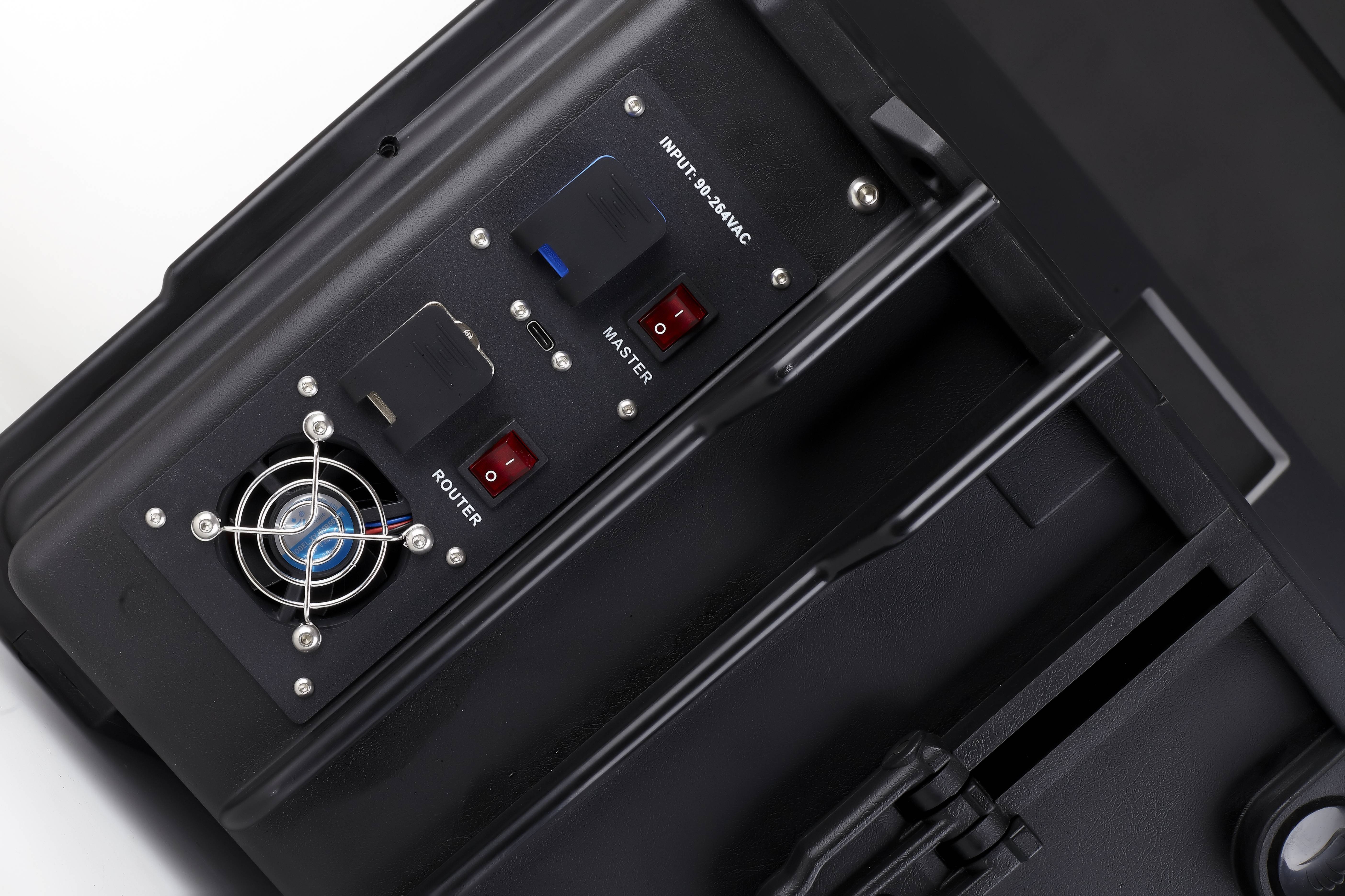 Nahaufnahme eines schwarzen elektronischen Bedienfeldes mit einem Kühlventilator, Anzeigelampen und beschrifteten Schaltern für „Router