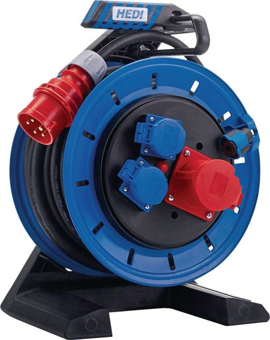 Eine blaue und schwarze industrielle Kabeltrommel mit verschiedenen roten und blauen Steckdosen, die für elektrische Verbindungen verwendet wird, ist in Nahaufnahme zu sehen.