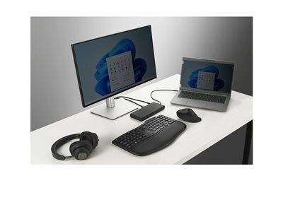 Ein Computeraufbau mit einem großen Monitor, der einen Kalender zeigt, einem Laptop, einer Tastatur, einer Maus und Kopfhörern auf einem weißen Schreibtisch.