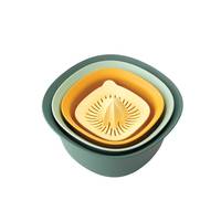 Ein Satz verschachtelter Küchenschüsseln in verschiedenen Farben mit einer Zitrusfruchtpresse oben, die Organisation und platzsparende Konstruktion demonstriert.