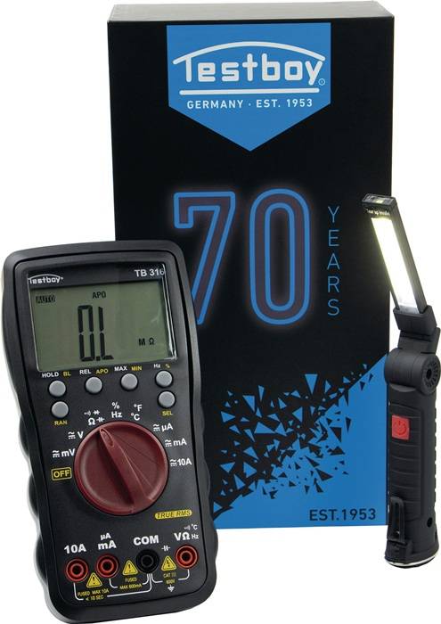 Ein digitales Multimeter, das '0L' auf dem Bildschirm anzeigt, neben dem Text '70 Jahre Deutschland Gegr. 1953' auf einem Schild mit dreieckiger Gestaltung und einer Taschenlampe.