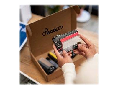 Eine Person hält eine durchsichtige Plastikbox mit farbigen Klebebändern neben einer offenen Pappschachtel mit der Aufschrift 