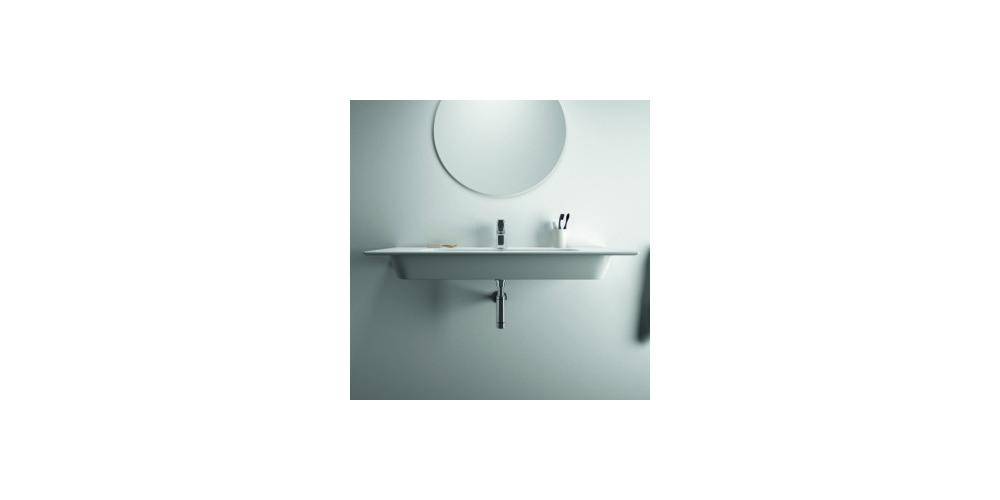 Minimales Badezimmerwaschbecken mit einem runden Spiegel über einem schmalen Wandregal, einem Wasserhahn und kleinen Toilettenartikeln vor einer hellen Wand.