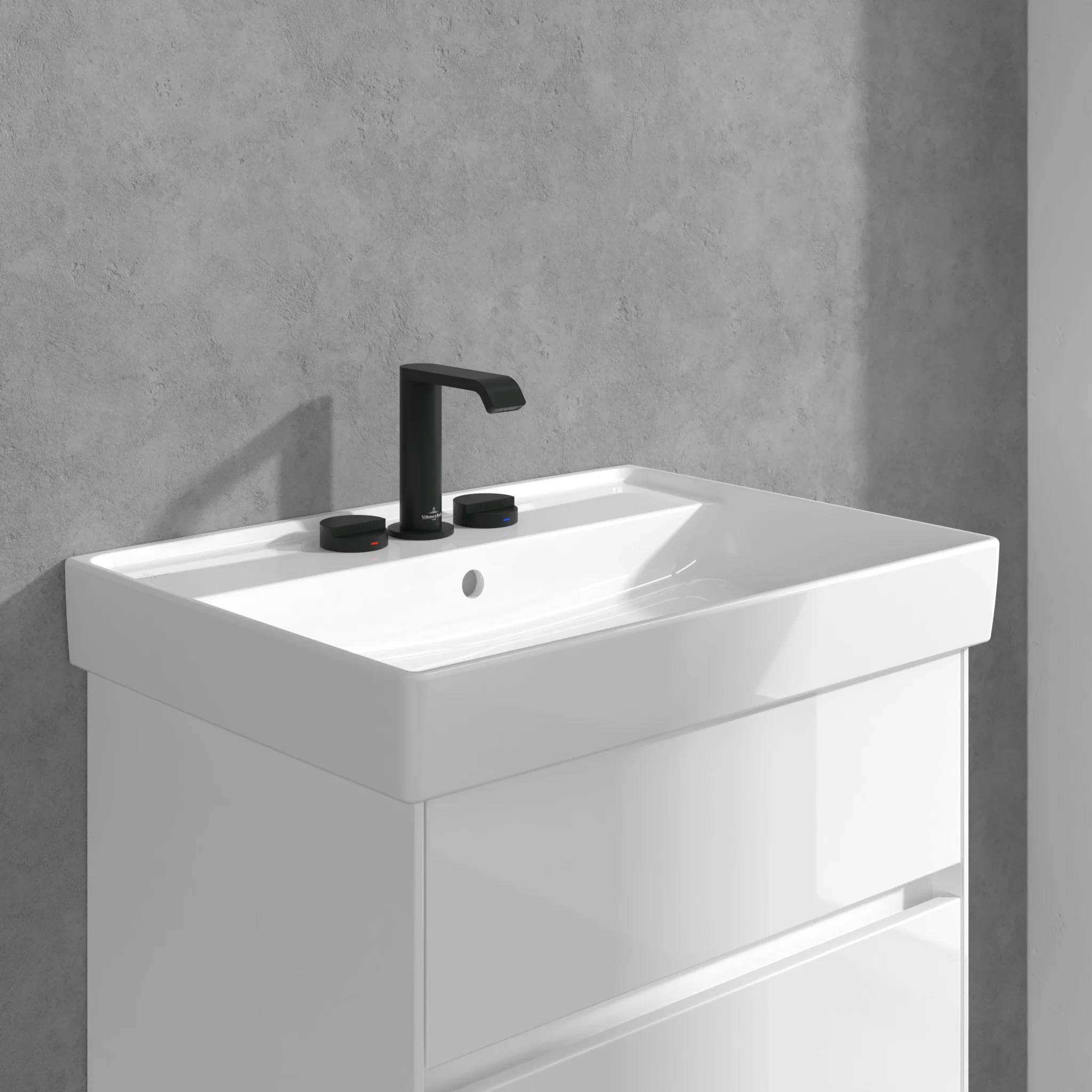 Weißes modernes Badezimmerwaschtisch mit integriertem rechteckigem Waschbecken und matter schwarzer Armatur vor einer grauen Wand.