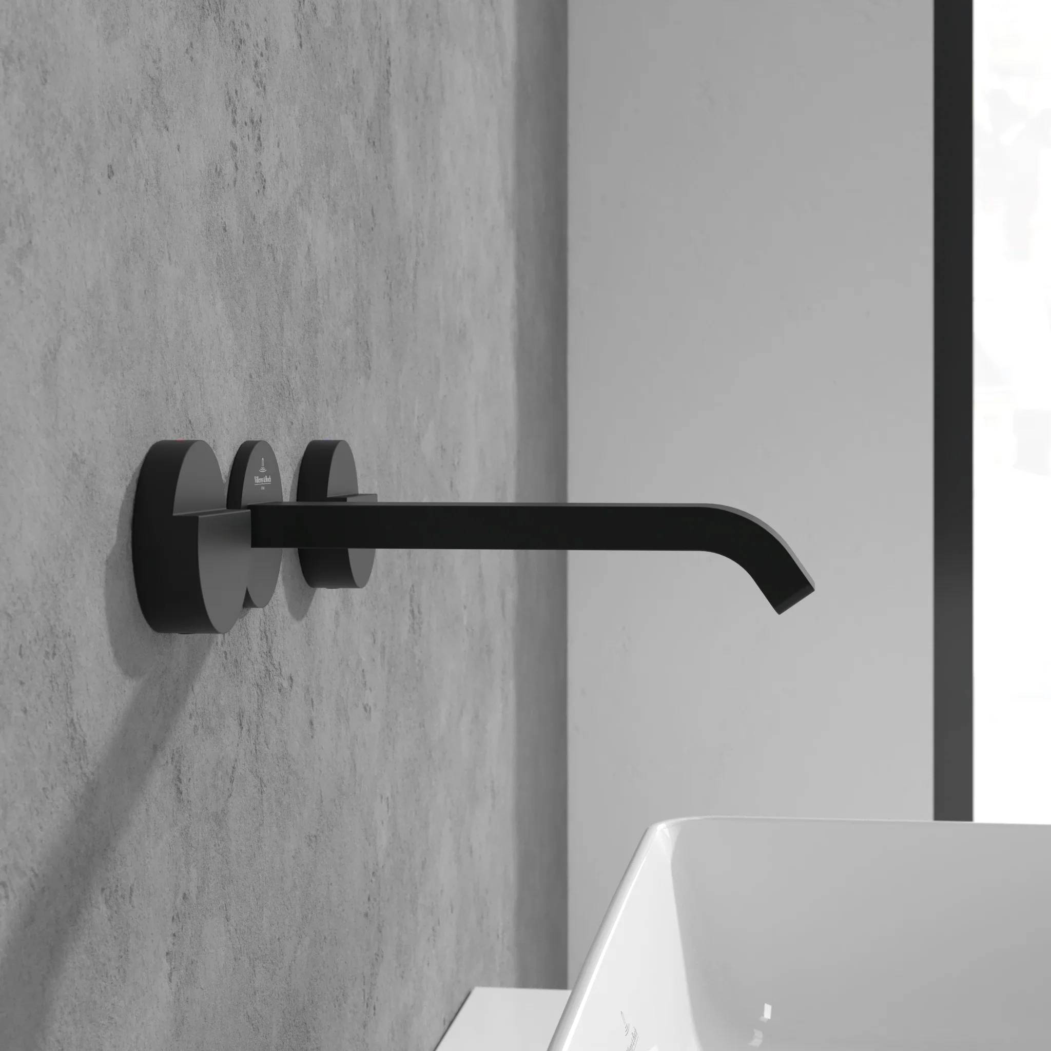 Schwarzer wandmontierter Wasserhahn mit geschwungenem Auslauf über einem weißen Waschbecken an einer grau gekachelten Wand.
