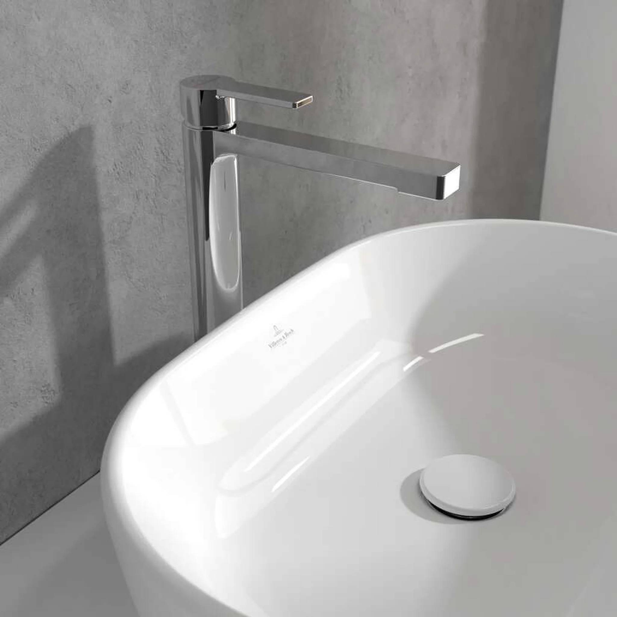 Modernes Badezimmerbecken mit weißem rundem Becken, verchromtem Einhebelmischer und grauem Betonwand-Hintergrund.