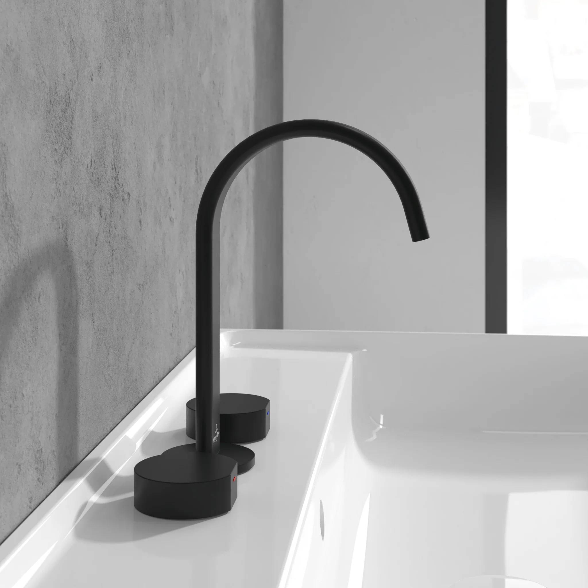 Modernes Badezimmerbecken mit einem mattschwarz glänzenden Schwanenhals-Wasserhahn auf einer weißen Arbeitsplatte vor einer grauen Wand.