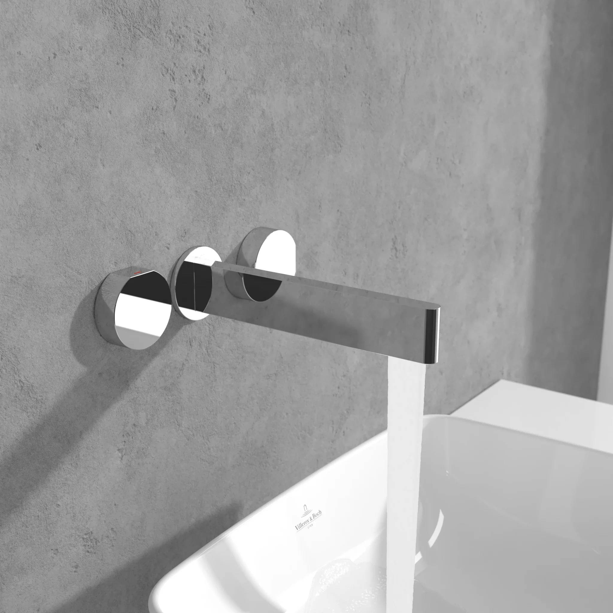 Moderner an der Wand montierter Badezimmerwasserhahn über einem weißen Waschbecken an einer grauen Wand.