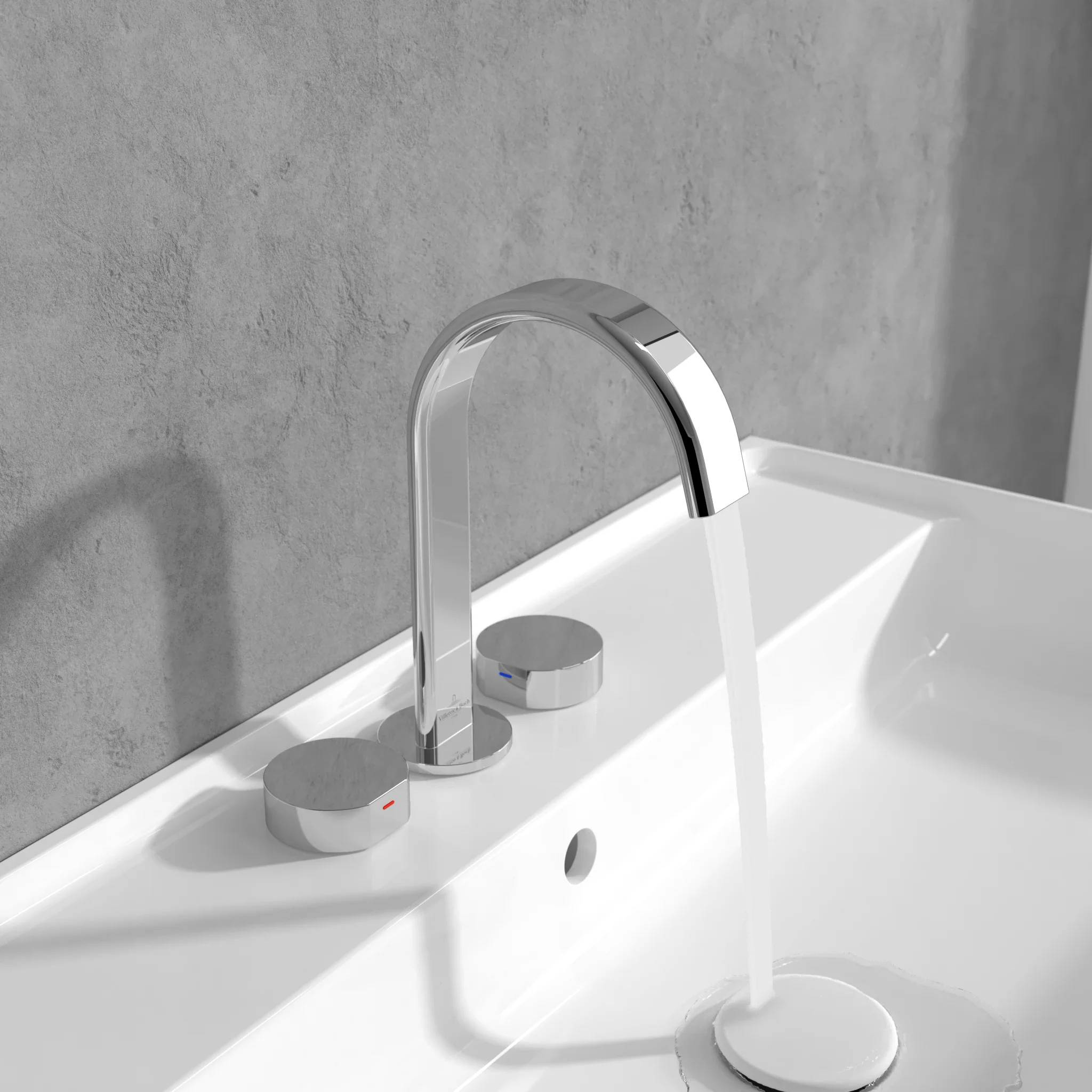 Moderner Chrom-Wasserhahn mit fließendem Wasser in einem weißen Badezimmerbecken an einer grauen Wand.