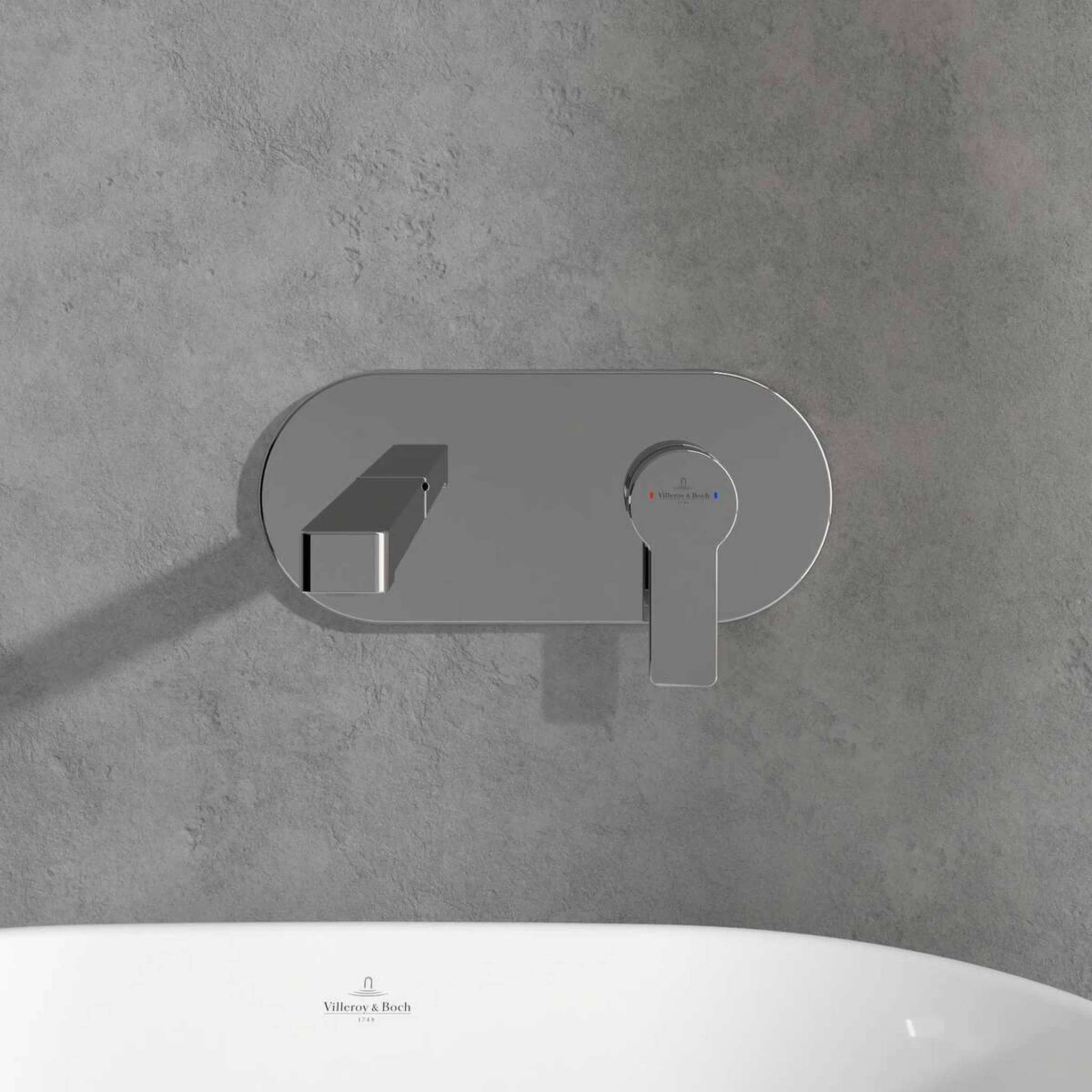 Moderner wandmontierter Chromwasserhahn über einer weißen Badewanne an einer grauen gekachelten Wand, zeigt eine schlanke Badezimmerarmaturen mit Hebelbedienung.