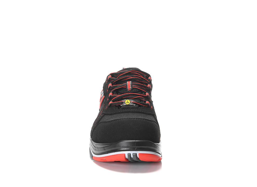 Ein einzelner schwarzer und roter Sportschuh, von vorne betrachtet, auf einer reflektierenden Oberfläche ruhend.