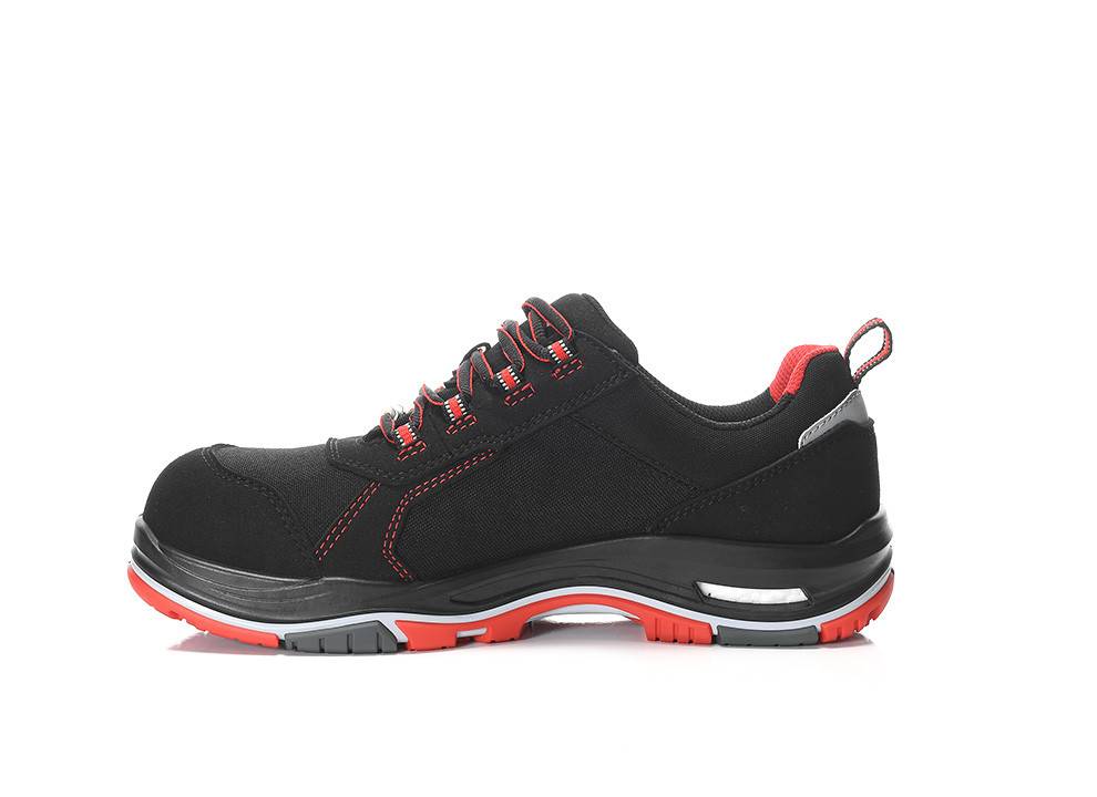 Ein schwarzer und roter Sneaker mit roten Nähten und einer robusten Sohle, entwickelt für Langlebigkeit und Komfort.